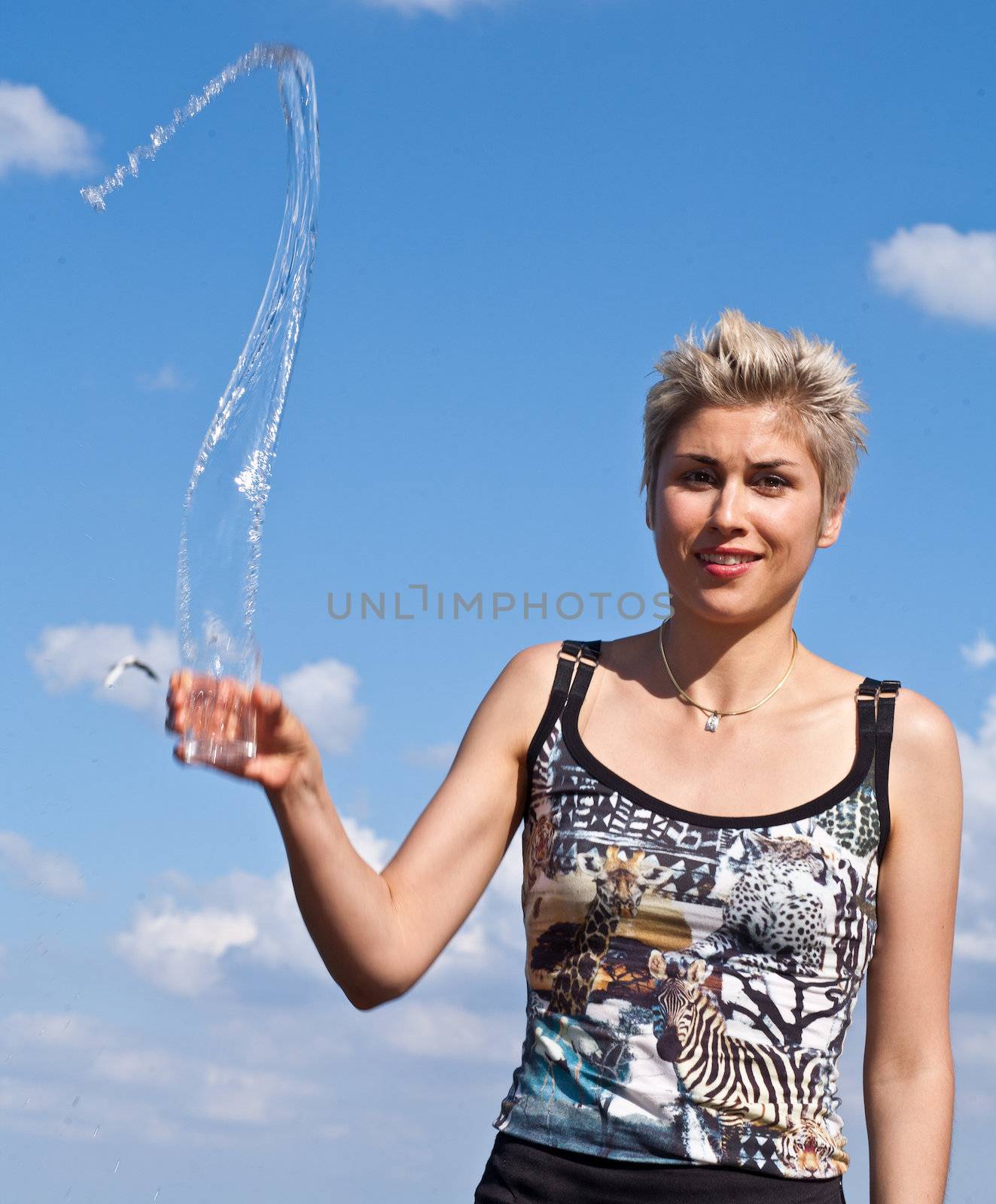 Cute blond girl playing with water in the summer in Denmark
