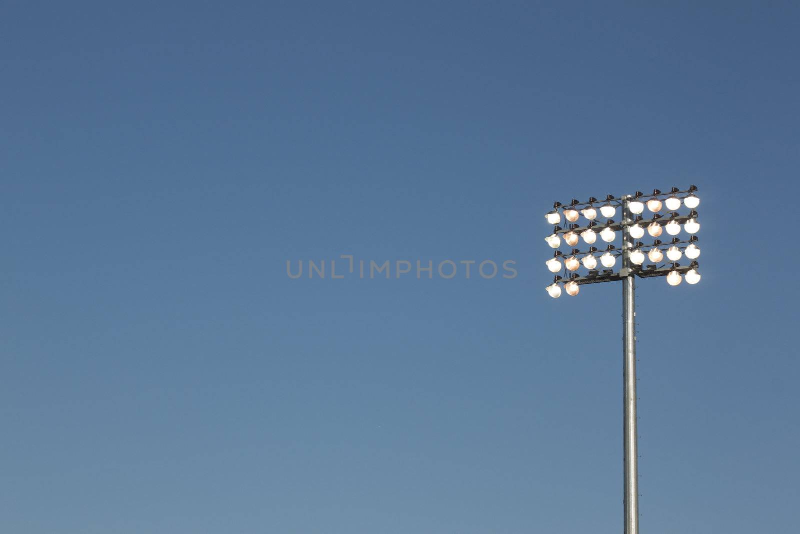 Stadium lights on a blue sky background by jeremywhat
