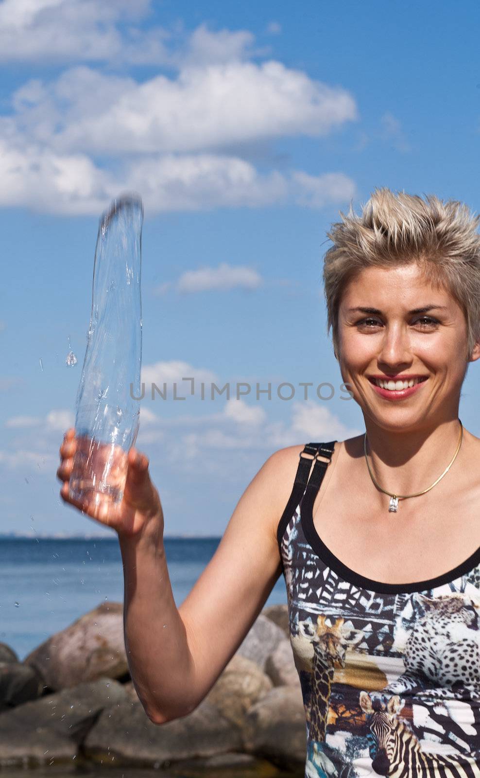 Cute blond girl playing with water in the summer in Denmark