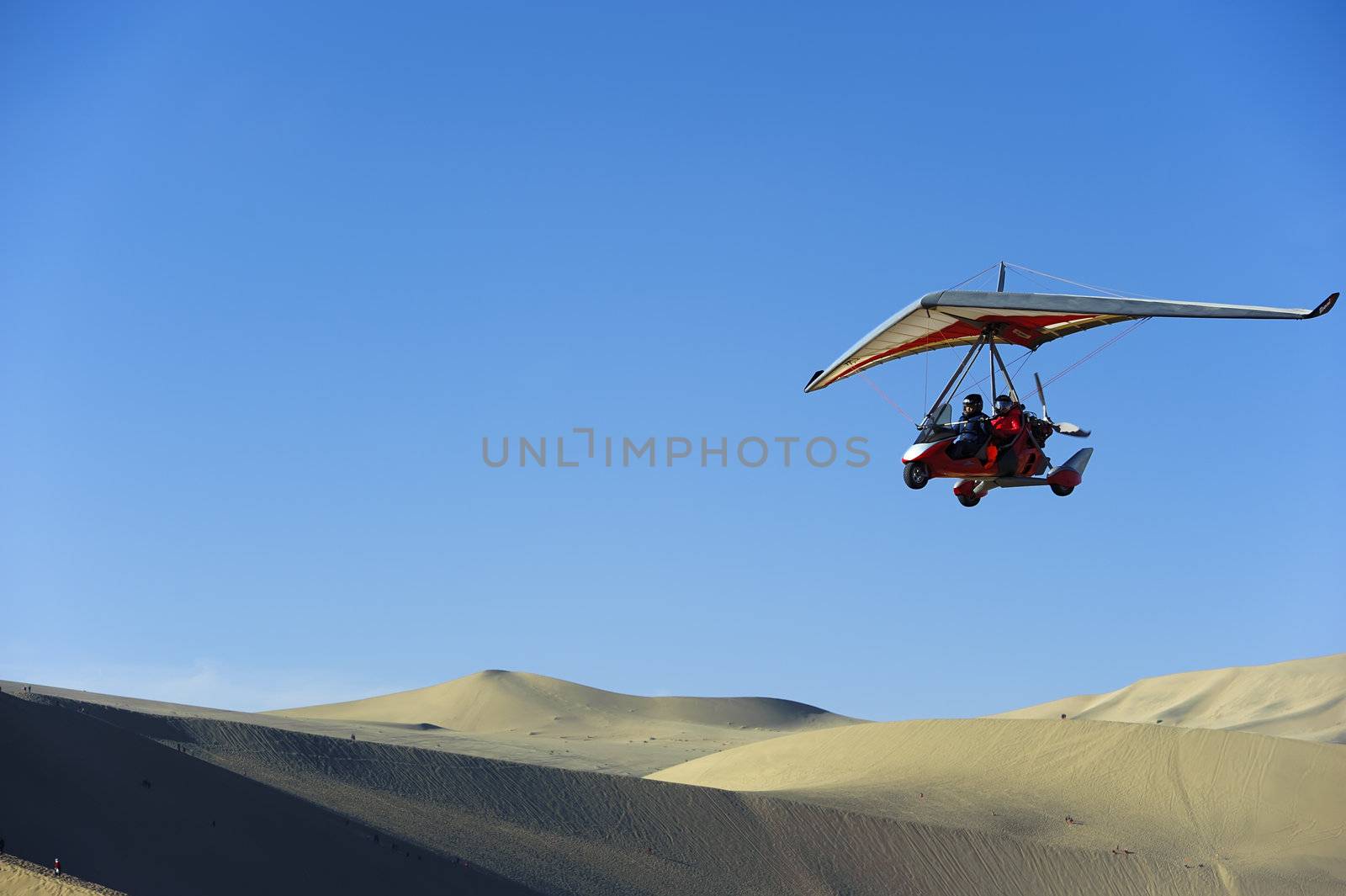 powered glider flying above the desert