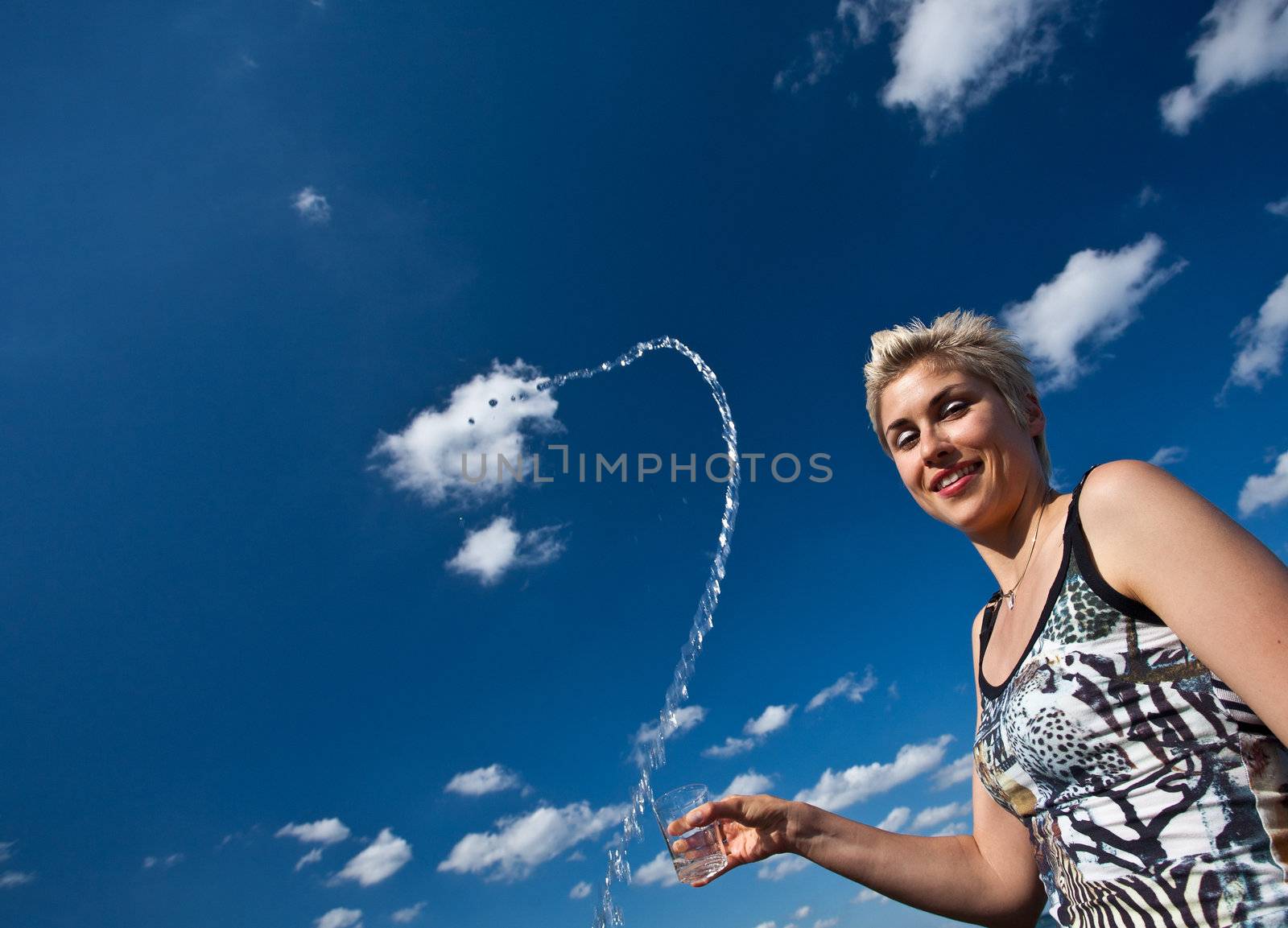 Cute blond girl playing with water in the summer in Denmark