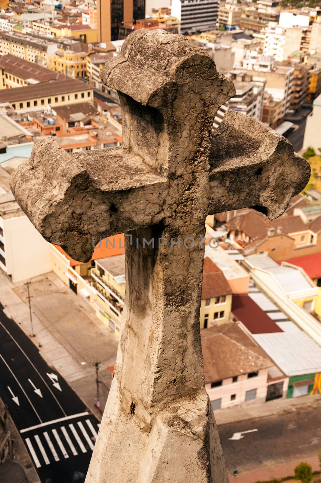 Closeup picture of cross on basilica in Quito, Ecuador with the city in the background