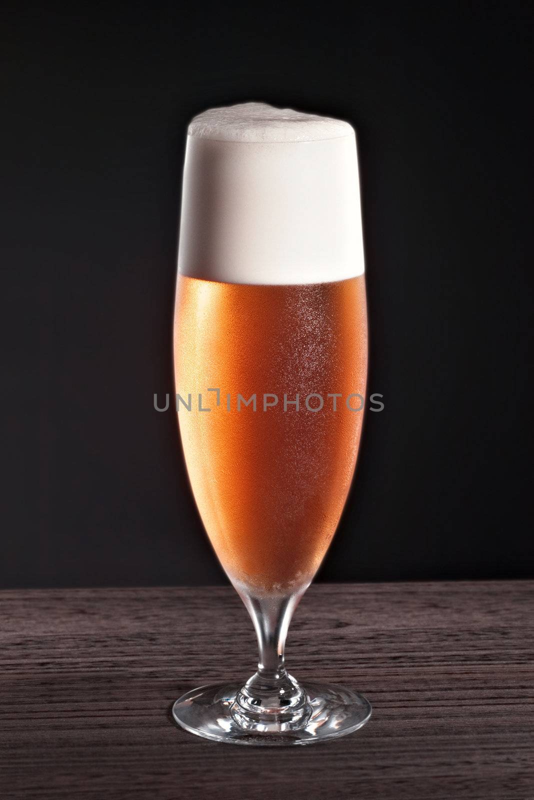 Beer into glass on a black background