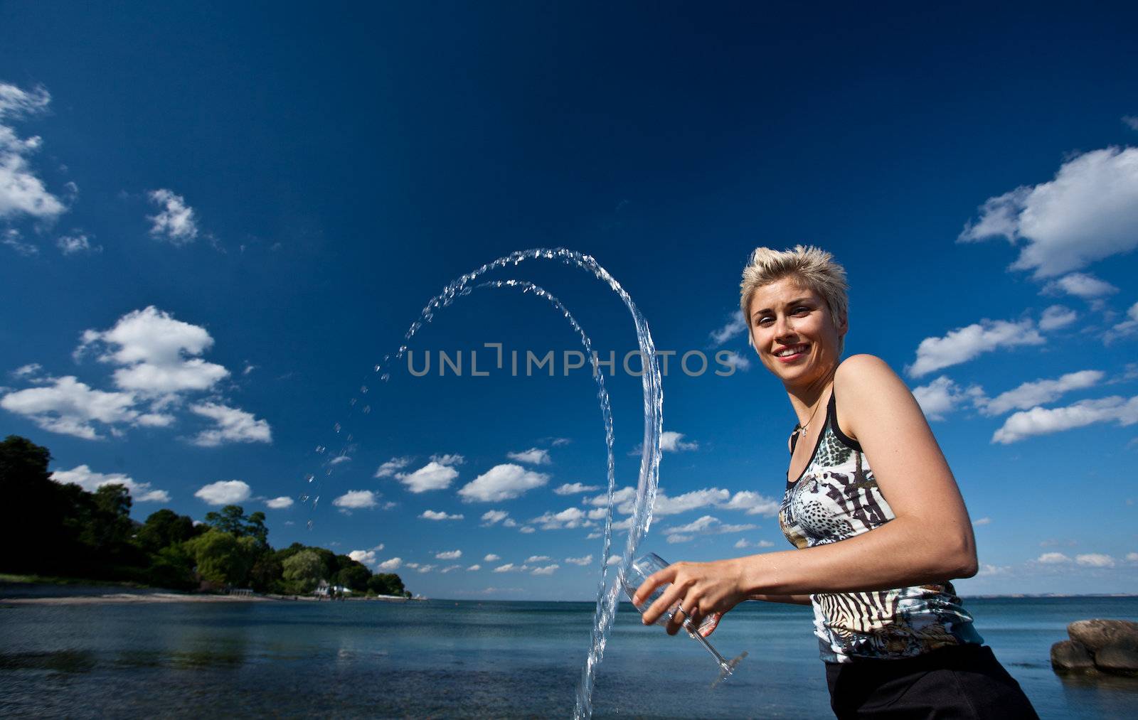 Cute blond girl playing with water in the summer in Denmark