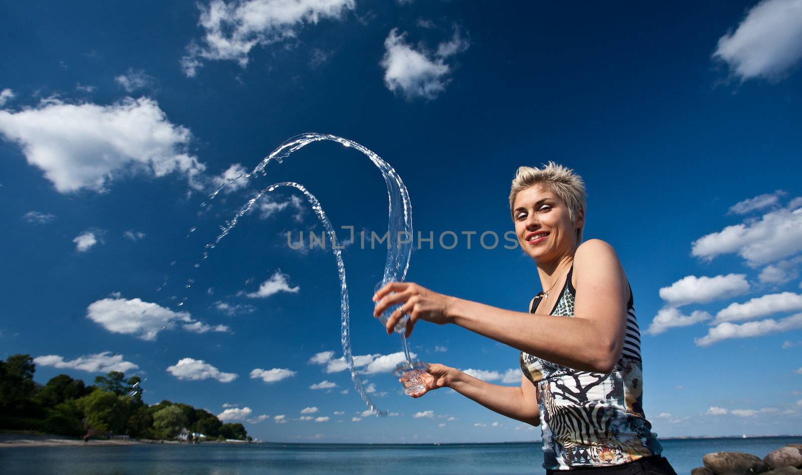 Cute blond girl playing with water in the summer in Denmark