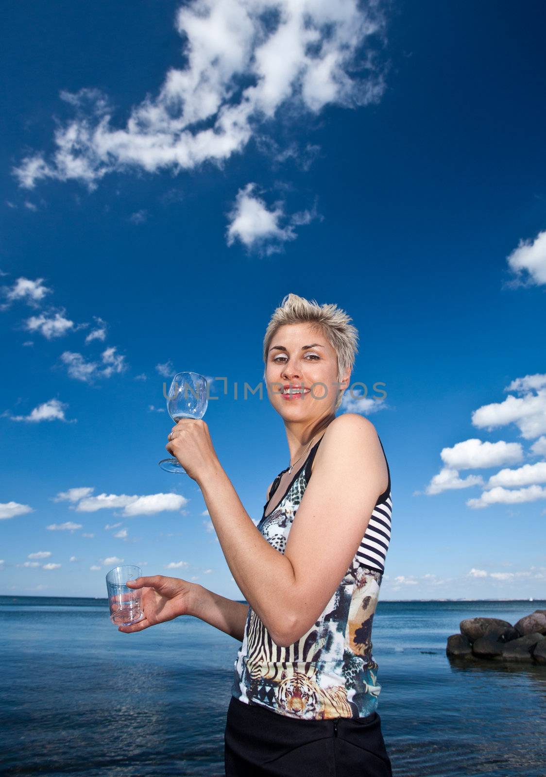 Cute blond girl playing with water in the summer in Denmark