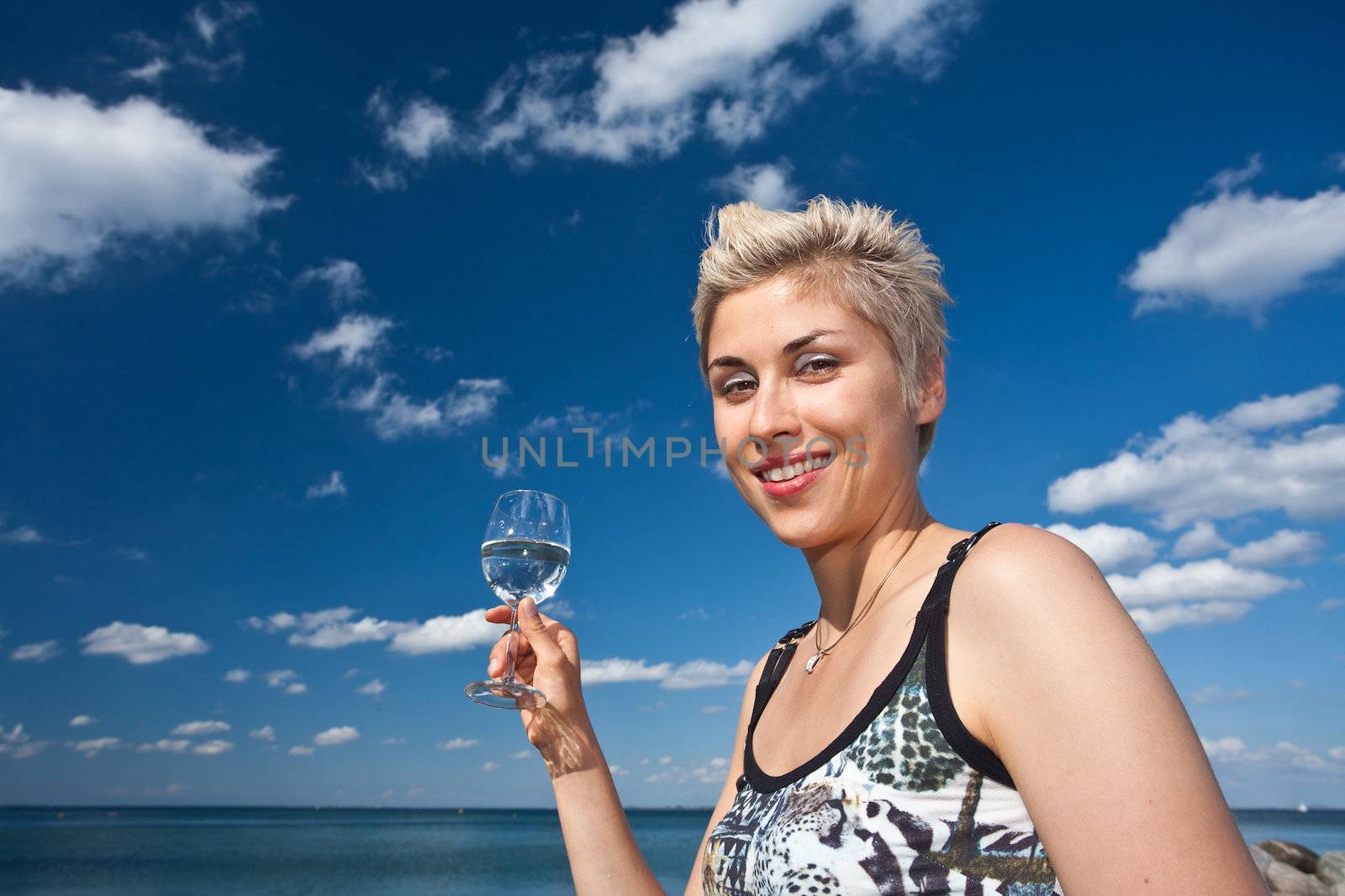 Cute blond girl playing with water in the summer in Denmark