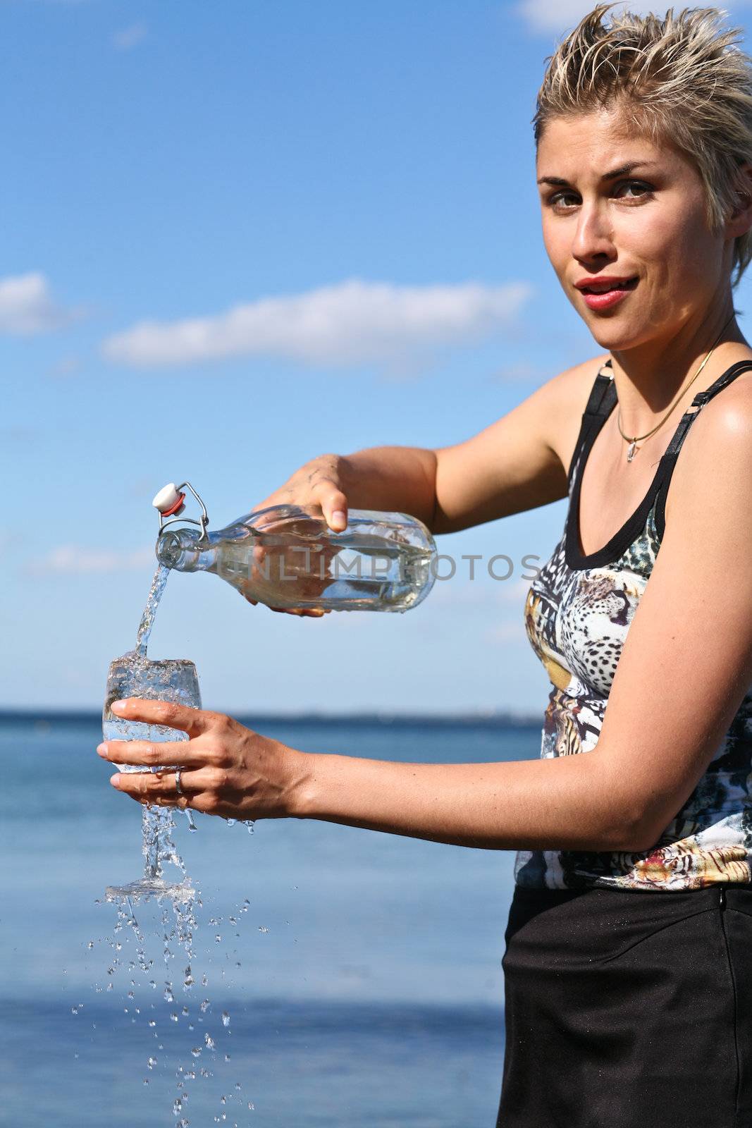 Cute blond girl playing with water in the summer in Denmark