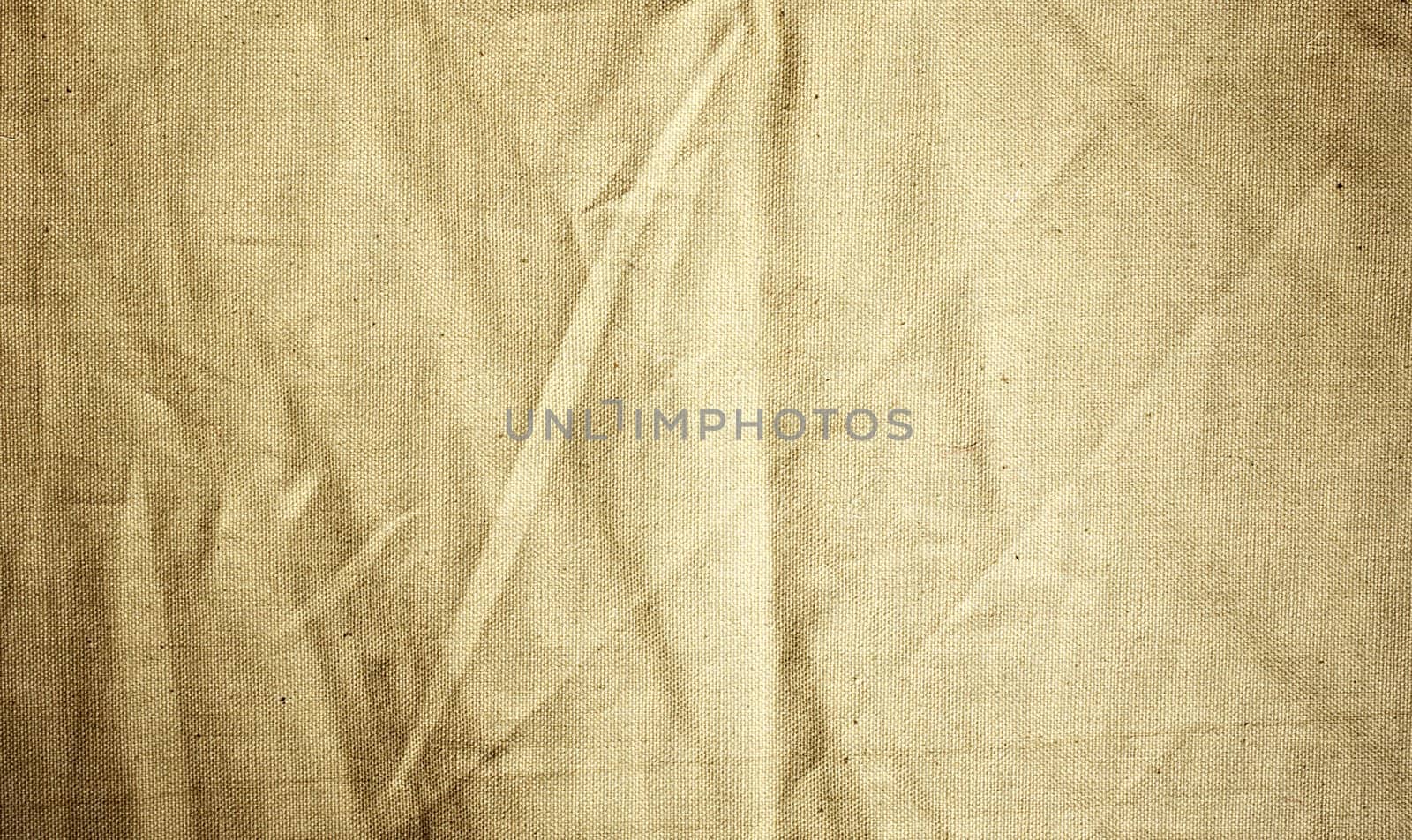 Background of crumpled dense fabric colored in beige tones