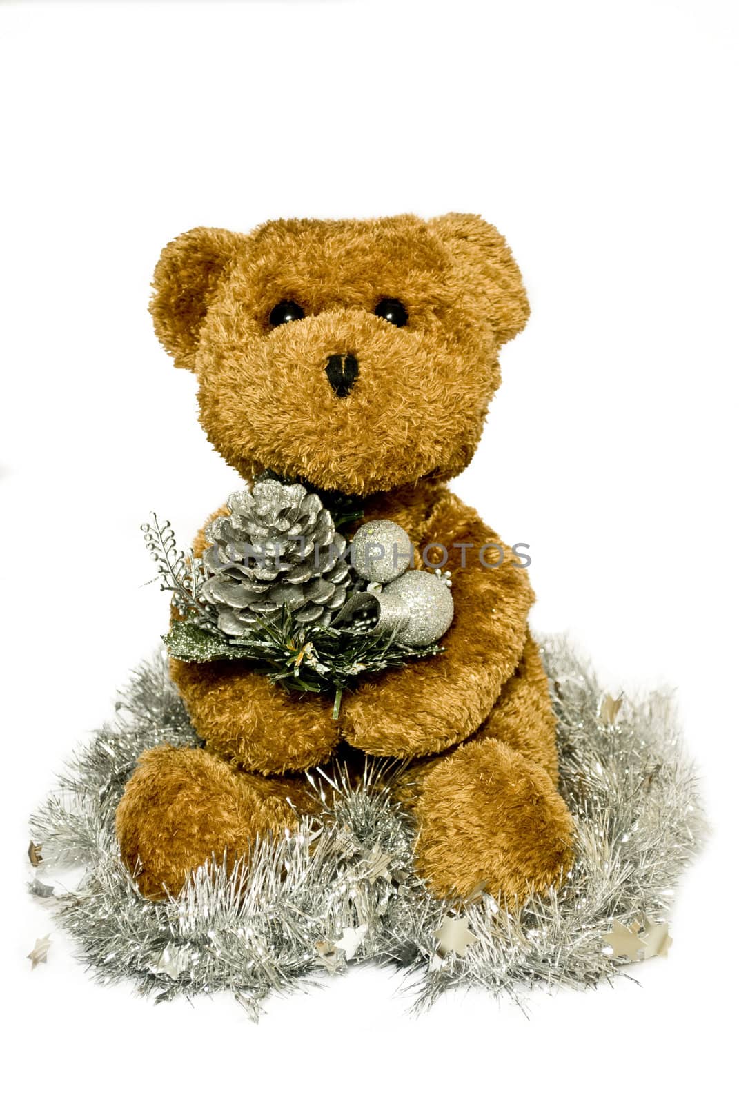 a brown bear hold a christmas decoration sat in tinsel 