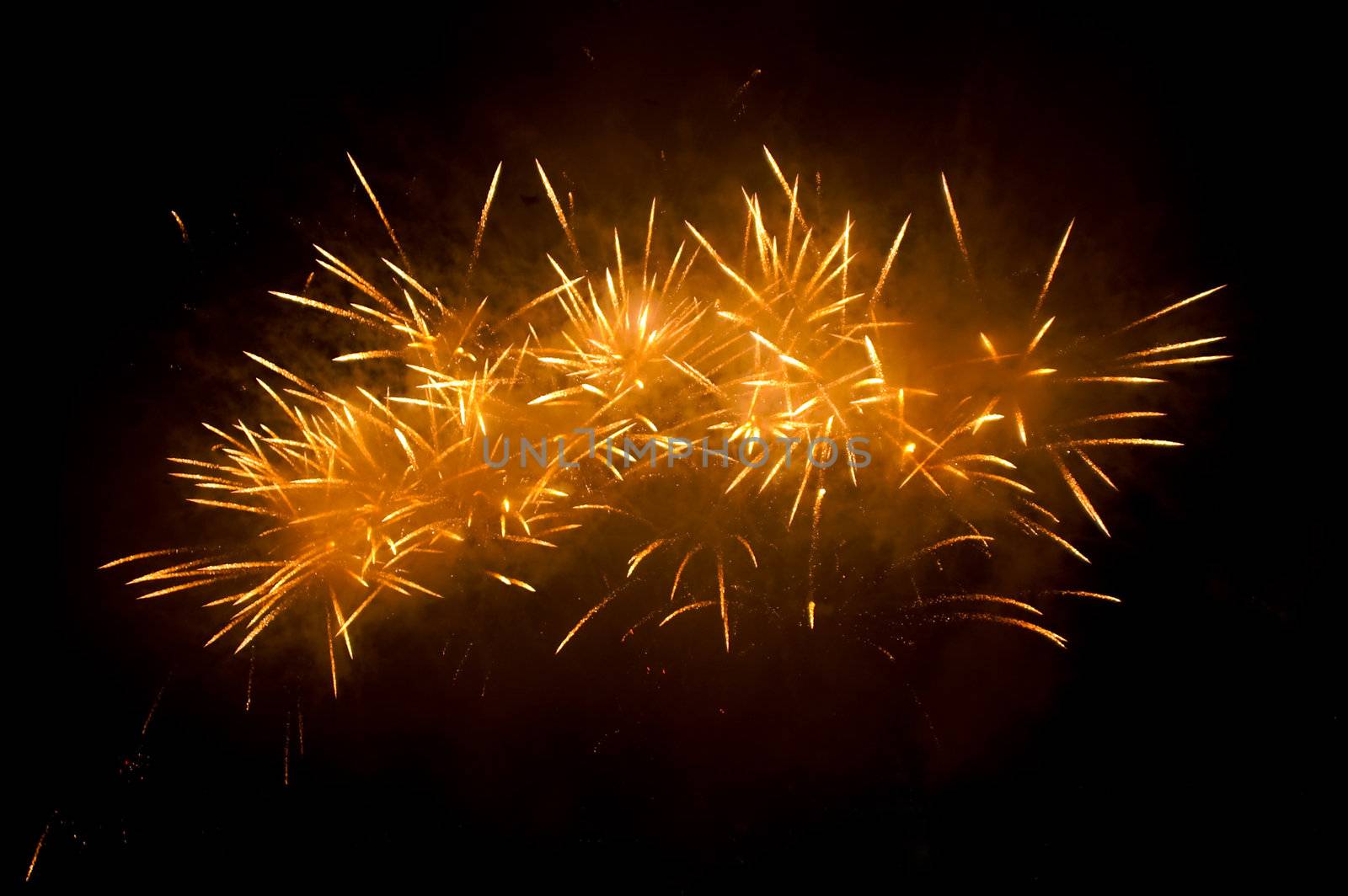 golden fireworks exploding high in the dark sky  