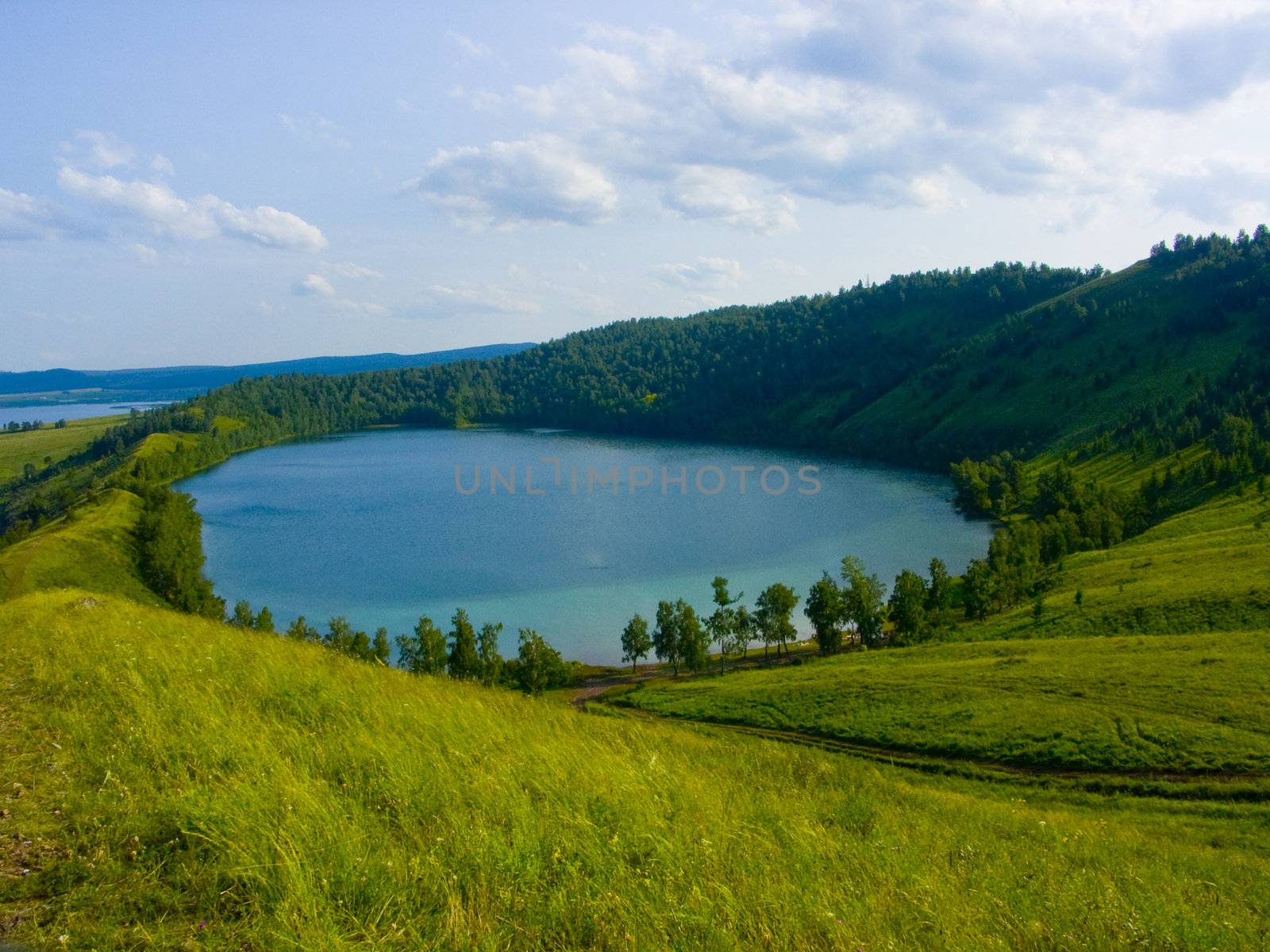 the image of the lake located in a hollow of a hill