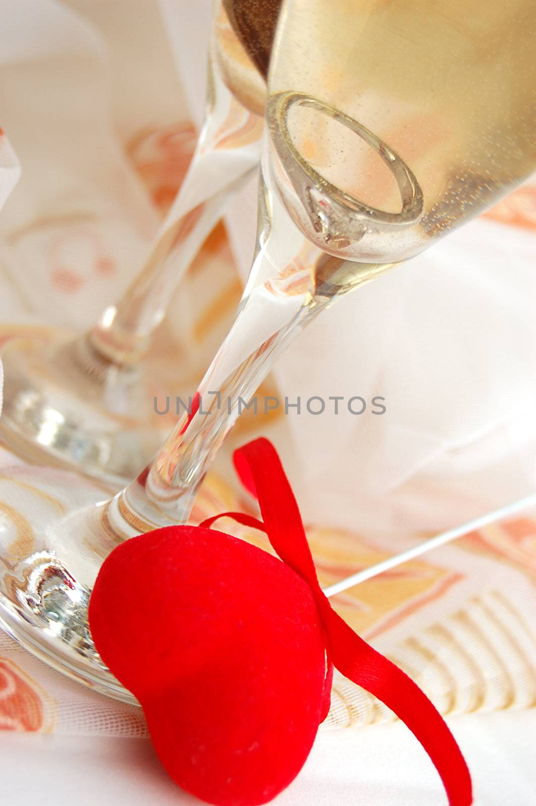 Two glasses of champagne and fabric heart in front