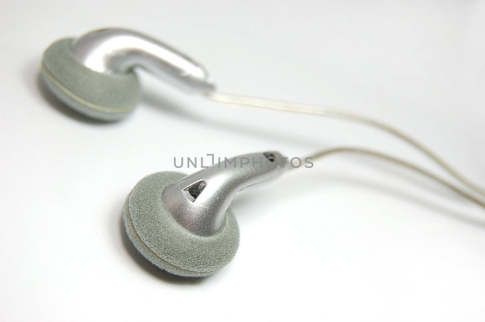 Small metallic headphones on slightly gray background