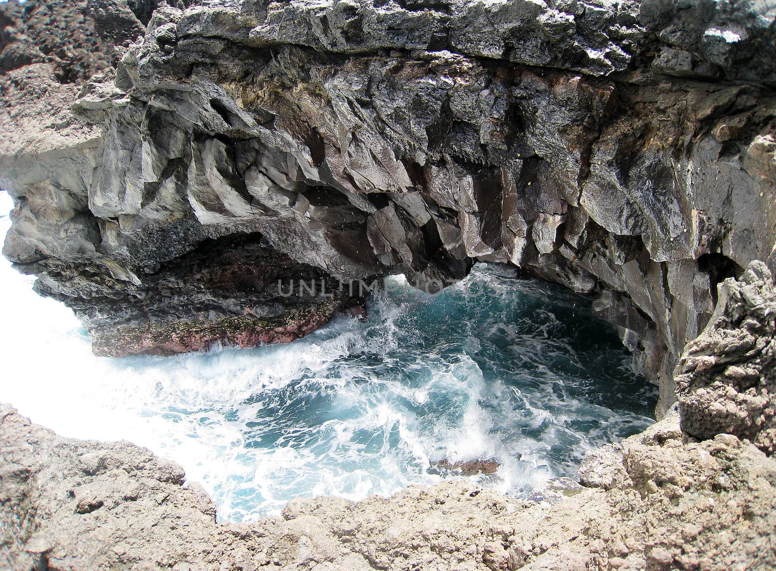 Waves crash into a reef cove