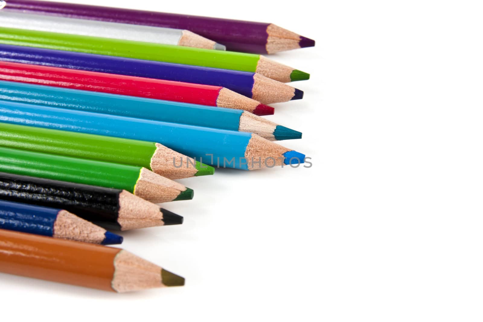 Color pencils in arrange in color wheel colors on white background with copy space