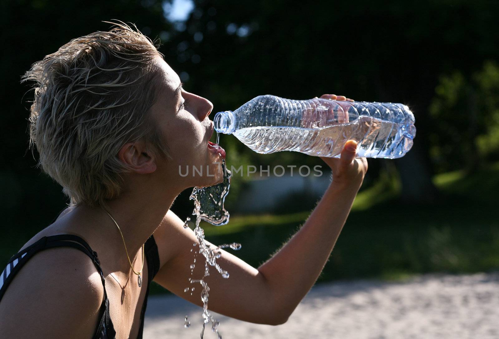 Cute blond girl playing with water in the summer in Denmark