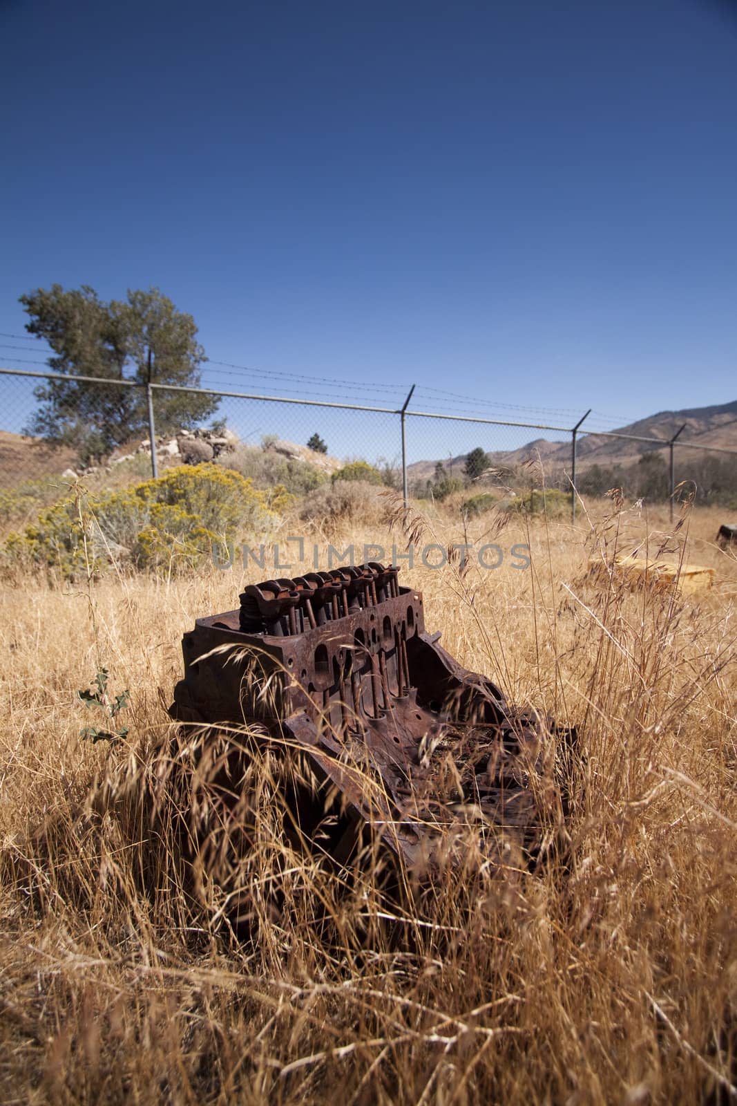 Old rusty engine block abandoned in the field.