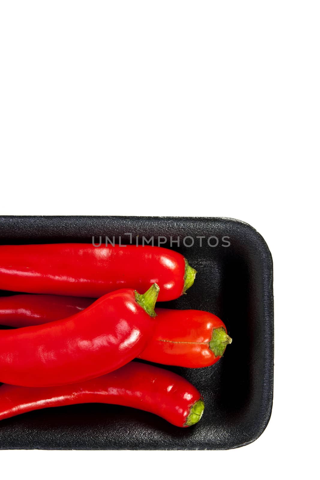 Fresh red hot pepper with black plate on a white background and blank text copy space