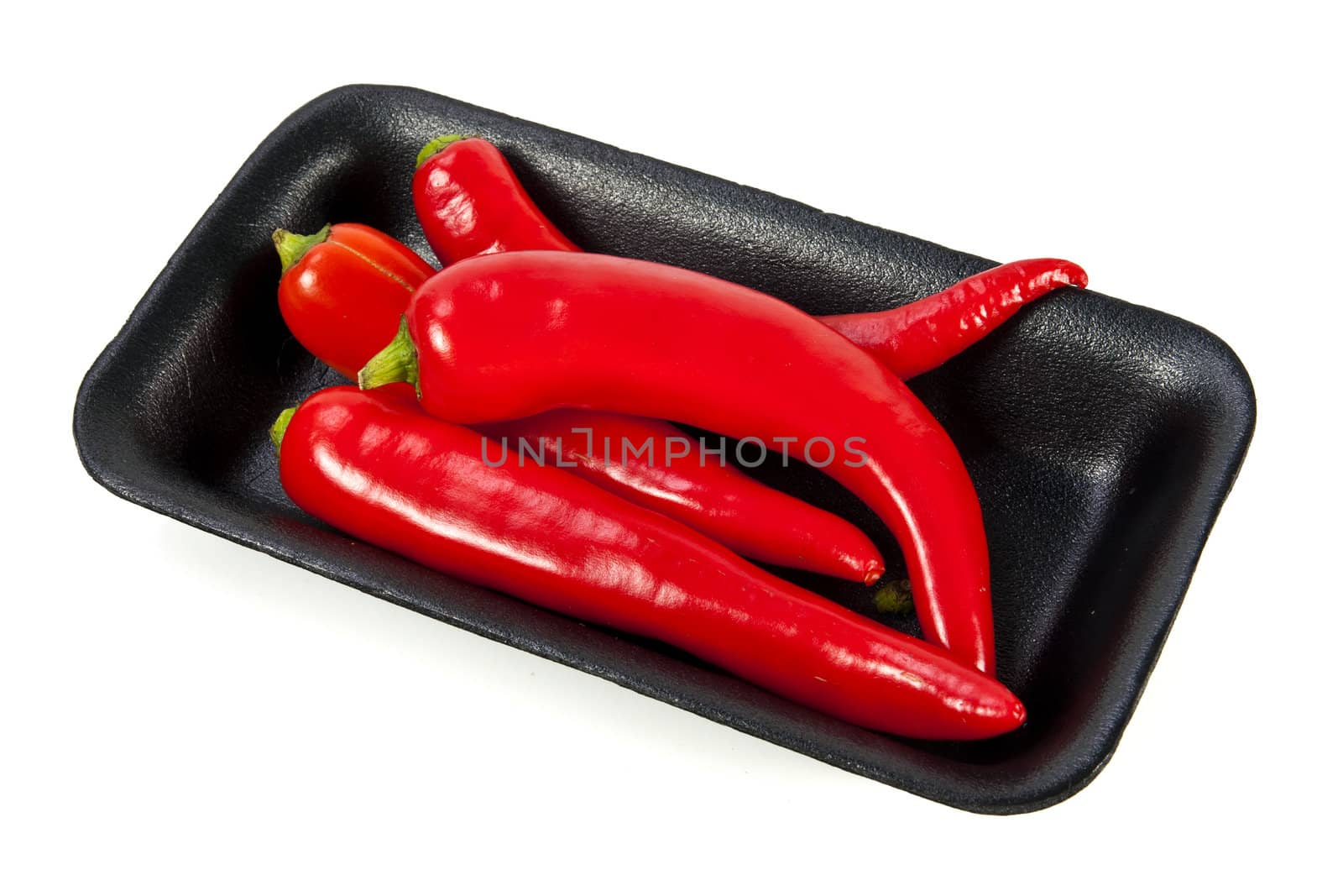 Fresh red hot pepper with black plate on a white background