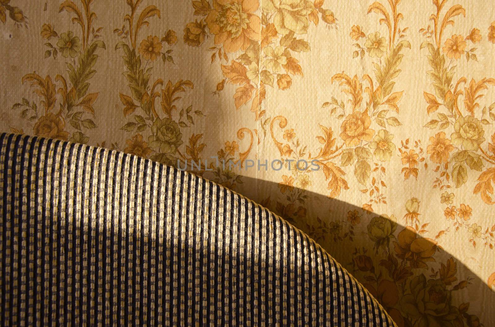 Old home interior design. Part of bed and wall with wallpaper background.