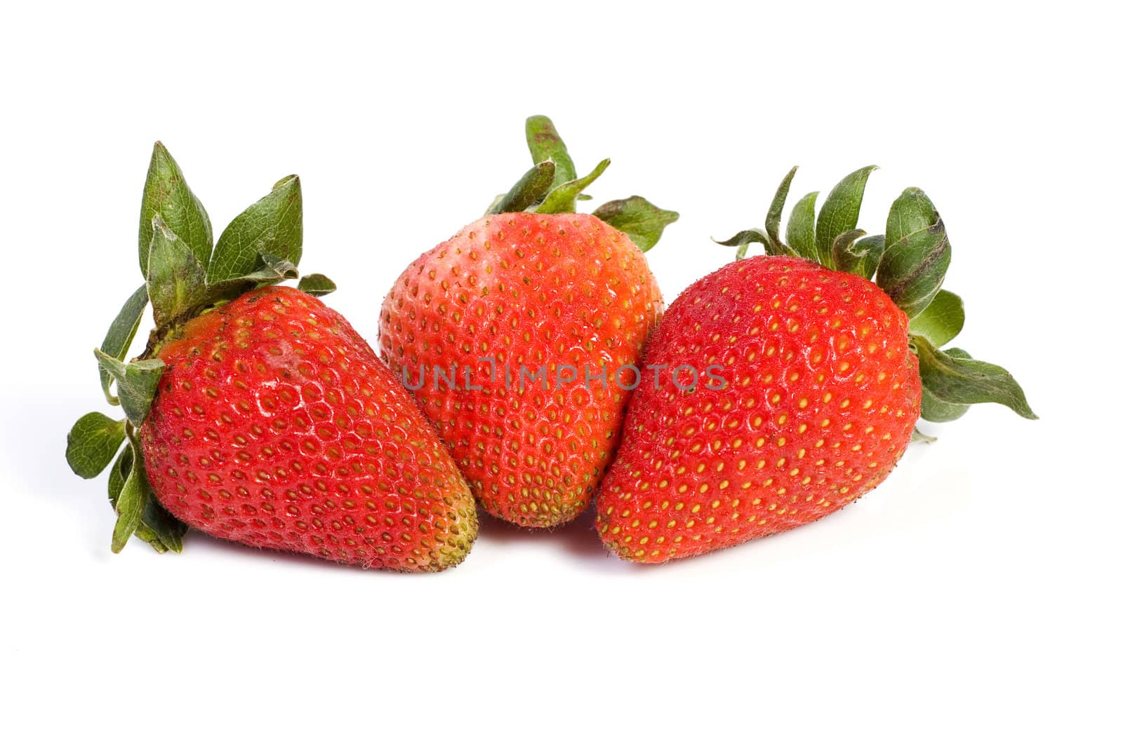 Three fresh ripe red strawberries, isolated on white with soft shadow.