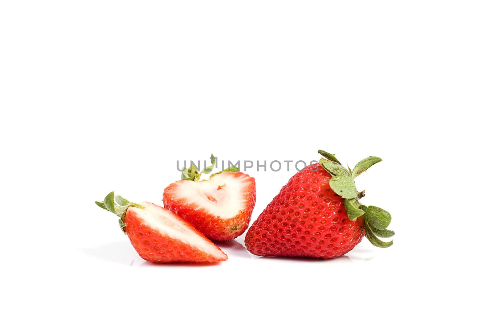 Fresh ripe red strawberries on white. The strawbery in front is sliced in half.