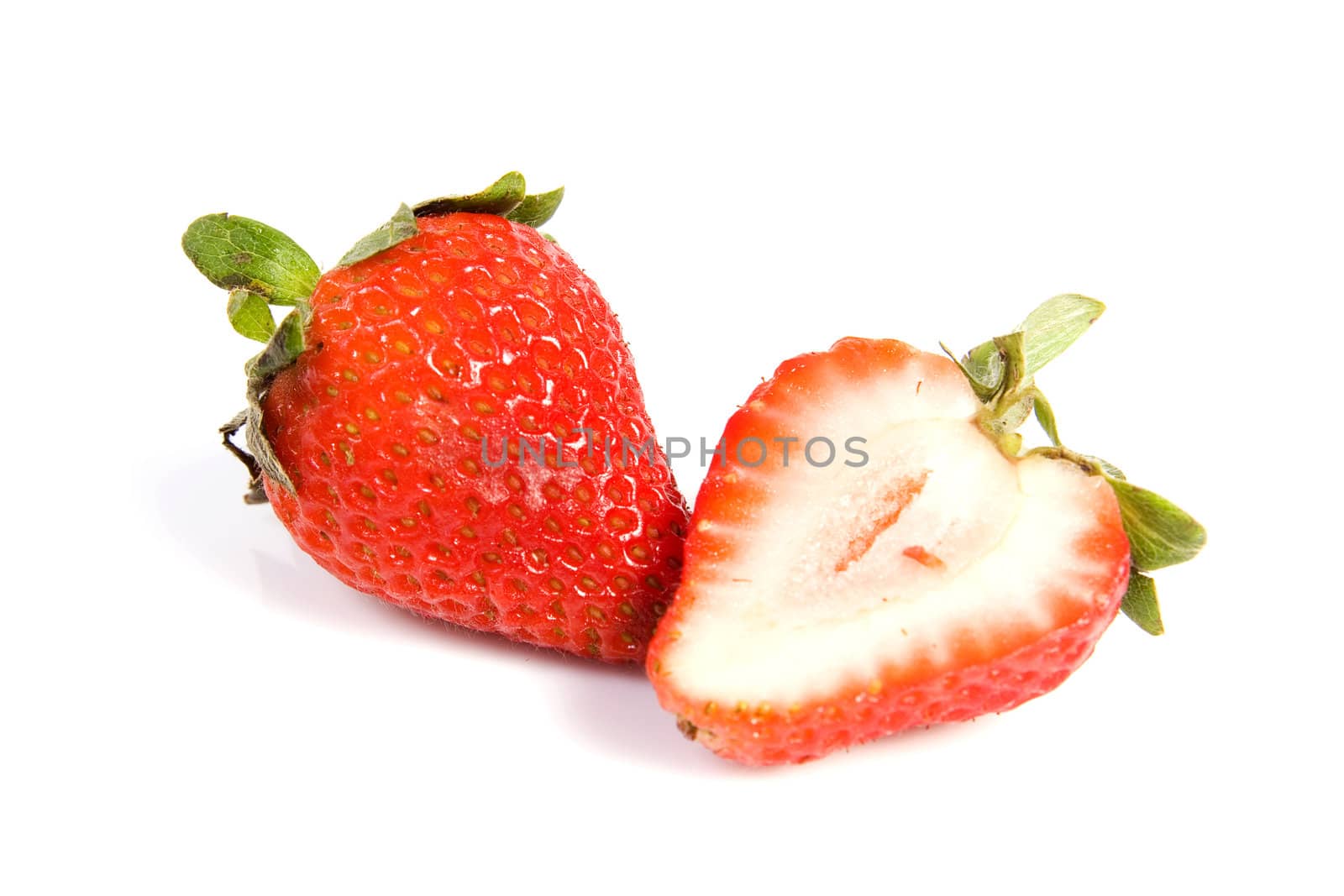 Fresh ripe red strawberries on white. The strawbery in front is sliced in half.