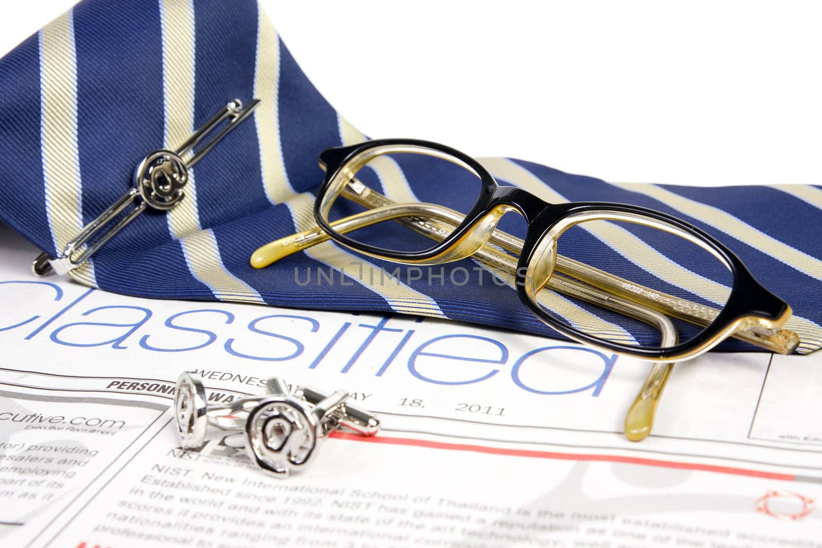 Jobs classified market on newspaper with ties tieclip cufflinks and glasses