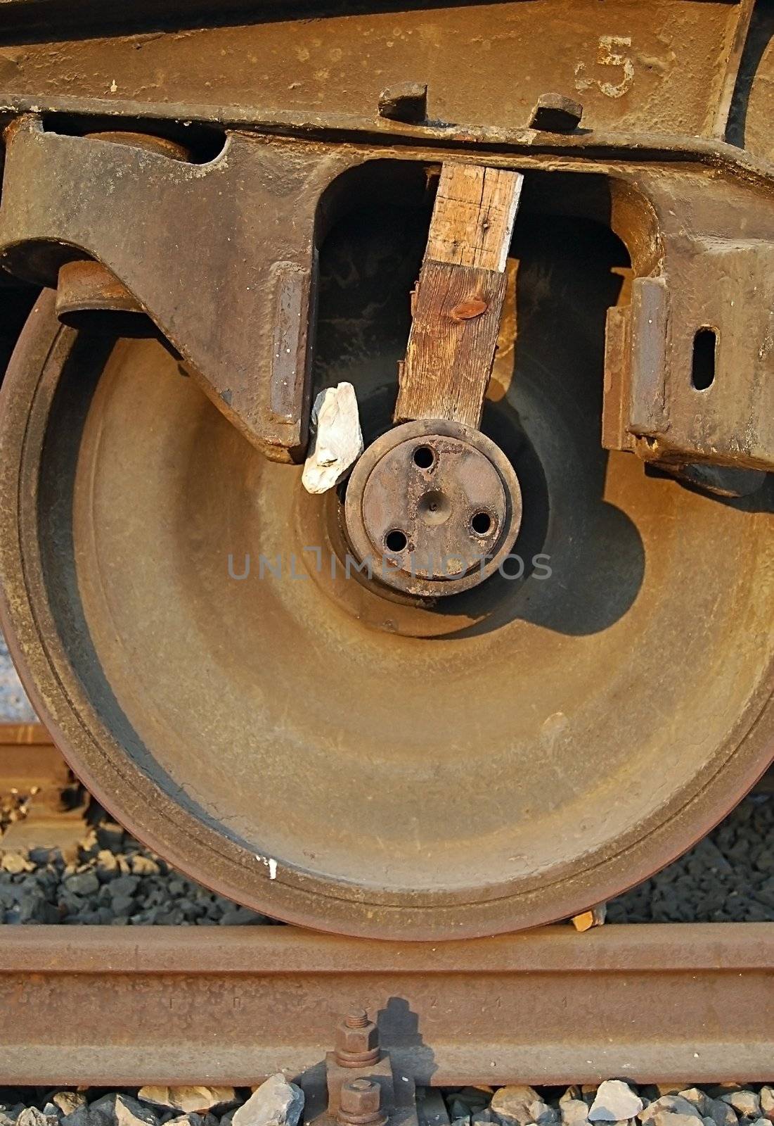 Old rusty freight wagon wedged wheel close-up