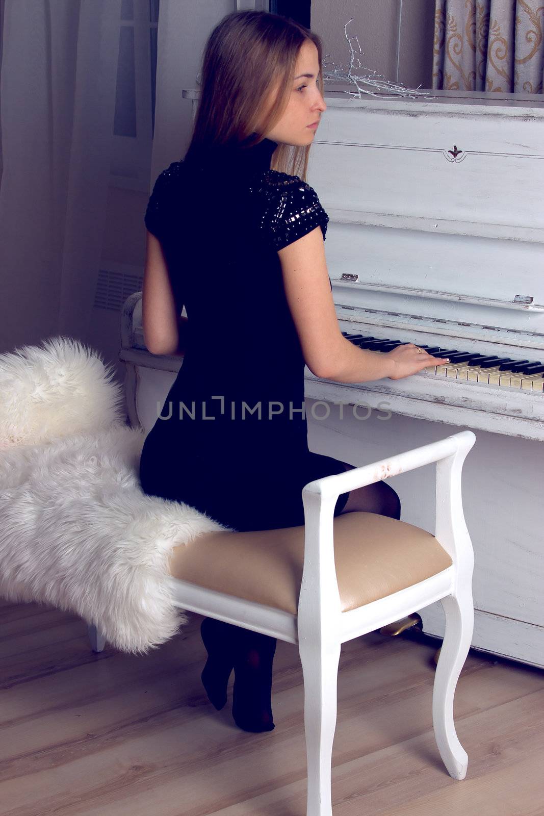 girl with blond long  hair in  dress playing white piano