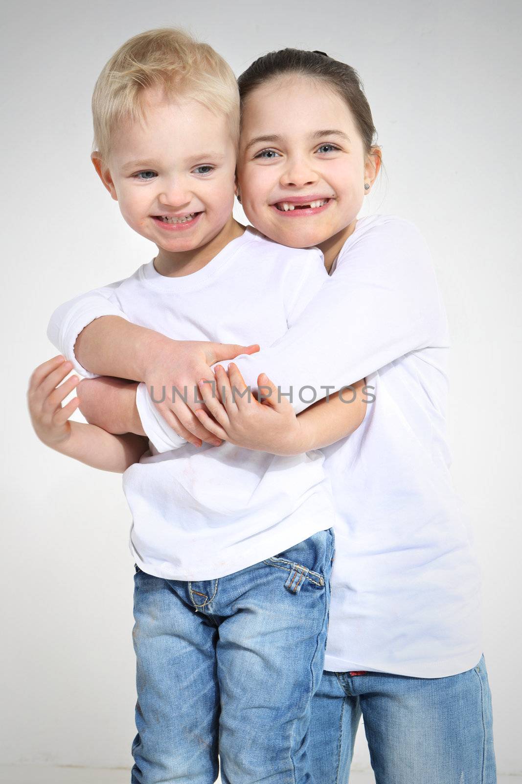 Brother and sister hugging isolated on white