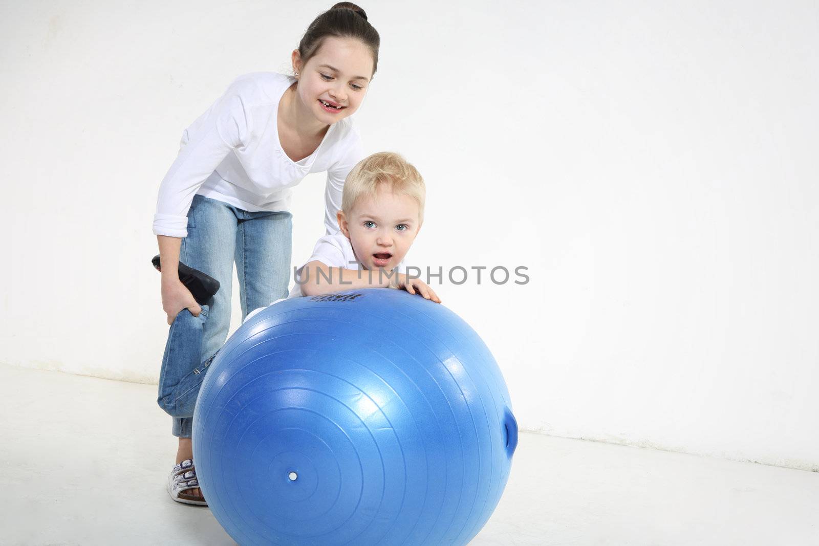 Brother and sister posing with a rubber ball