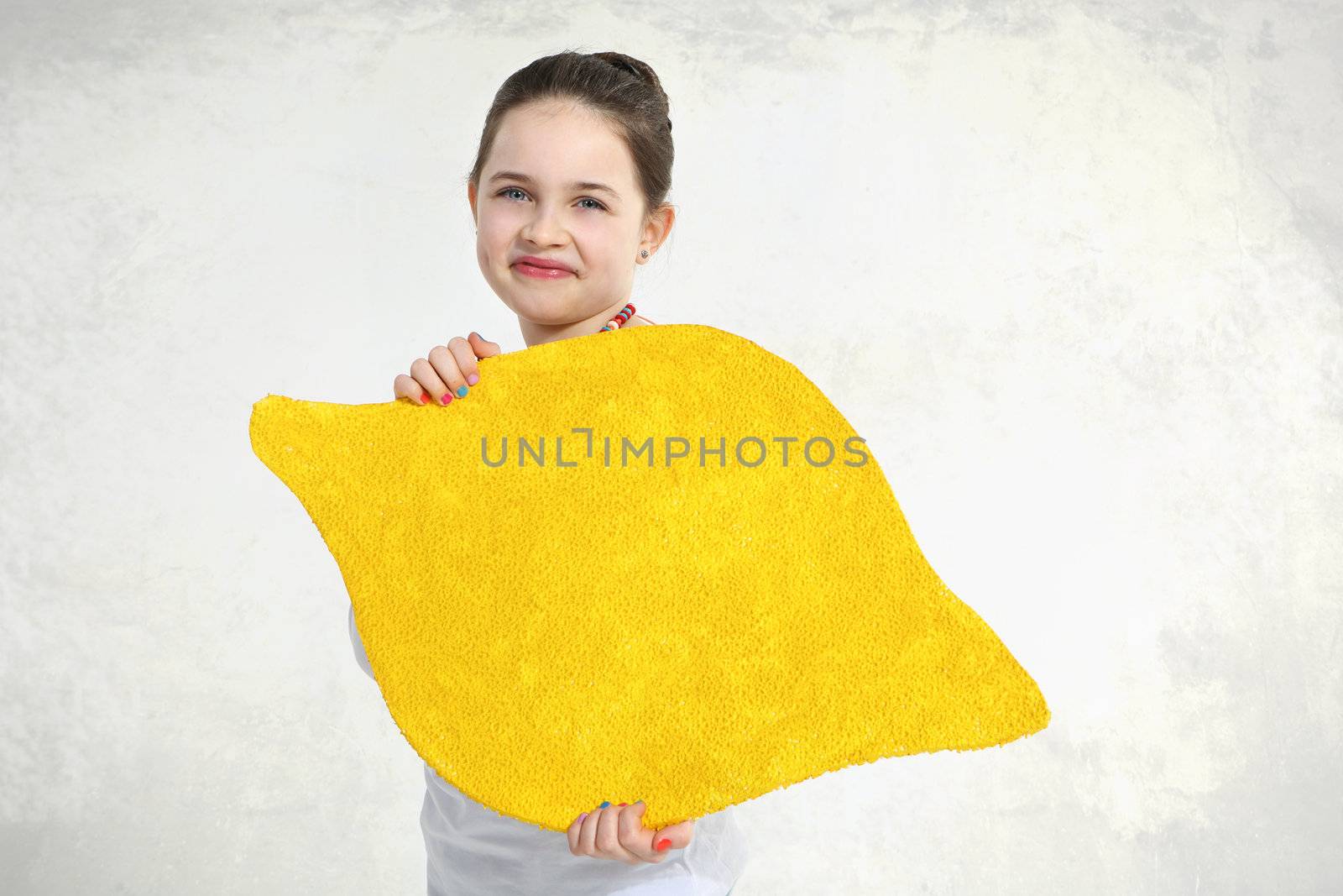 Little girl posing with painted lemon in studio