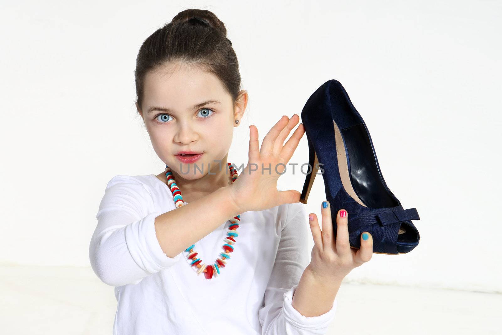 Little fashionista holding shoe in studio