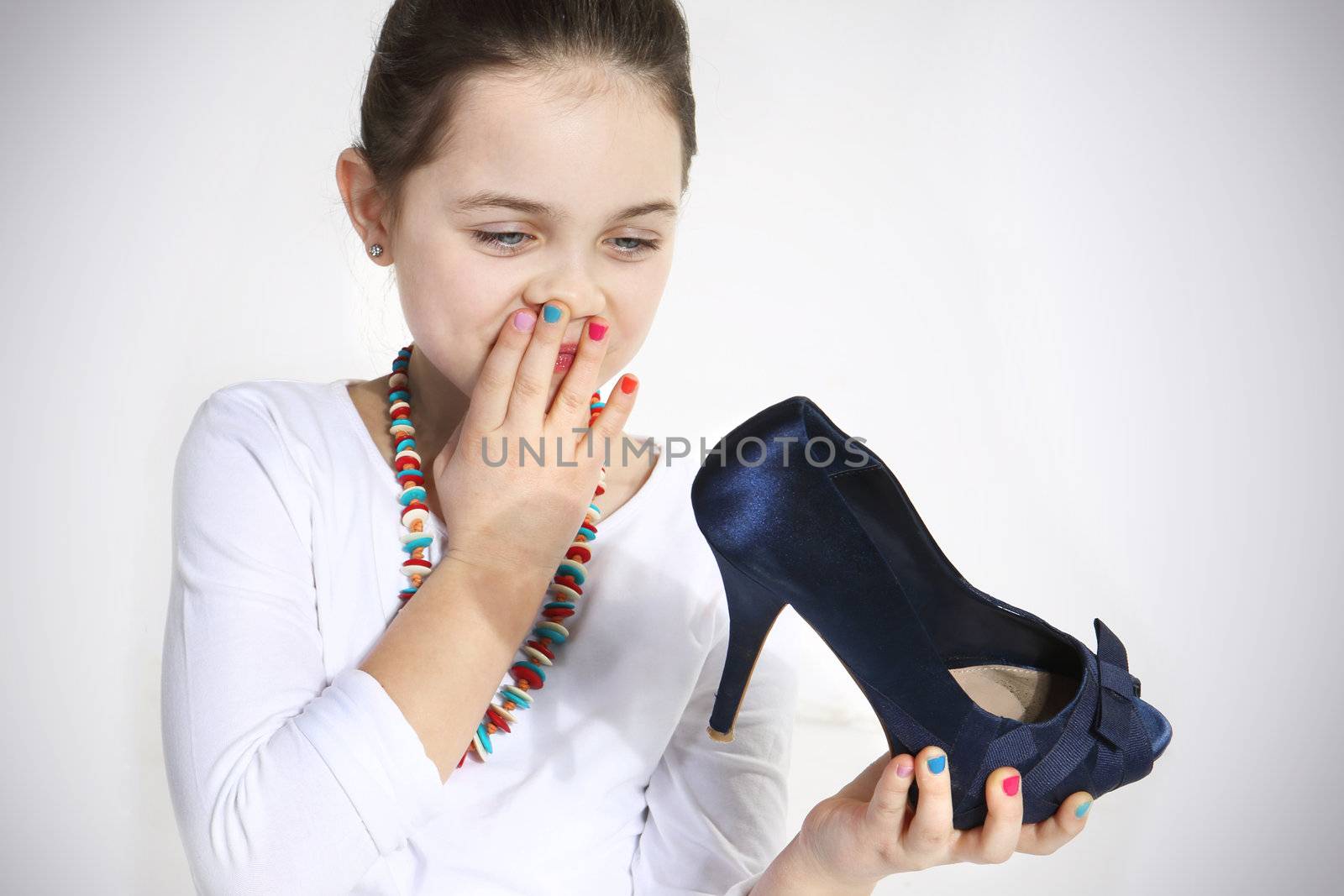 Little fashionista holding shoe in studio