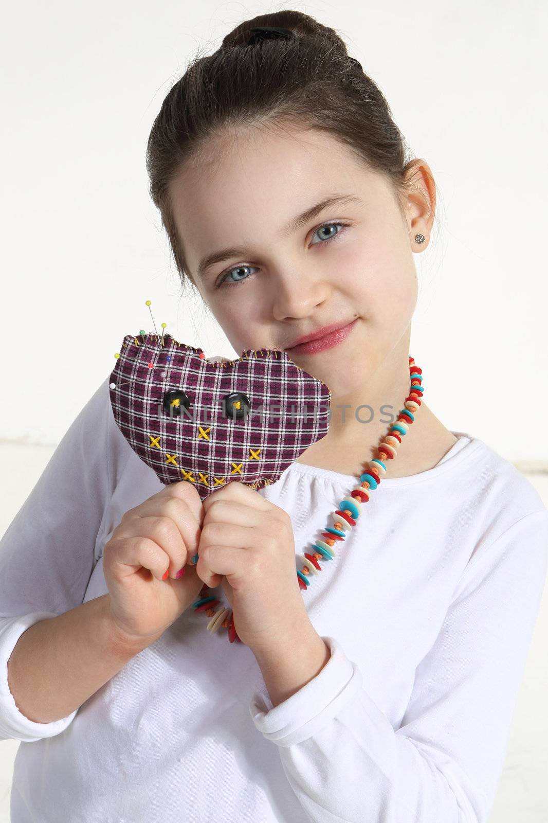 Girl posing with handmade toy isolated on white