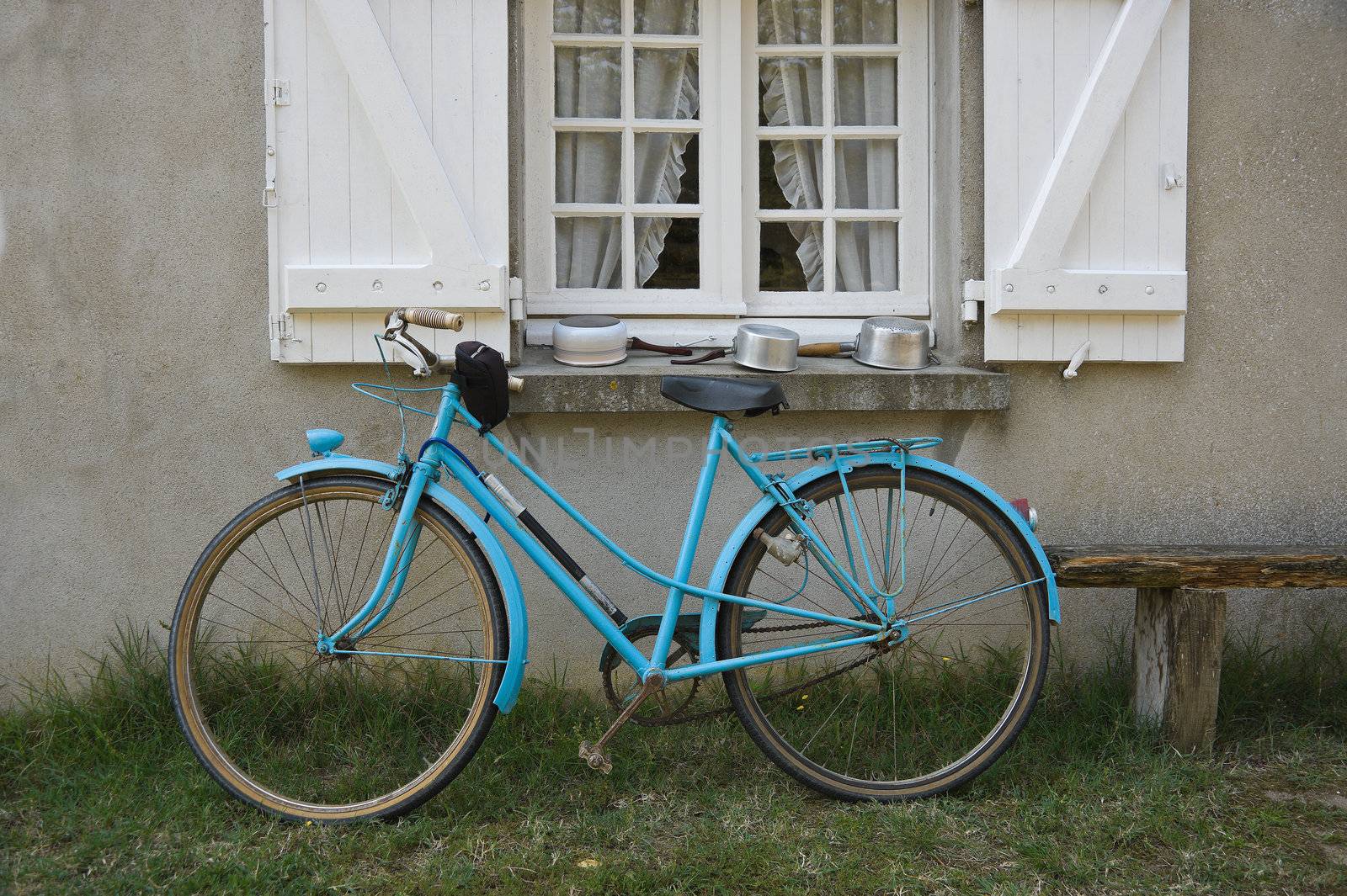 Old blue french bicycle in front of window
