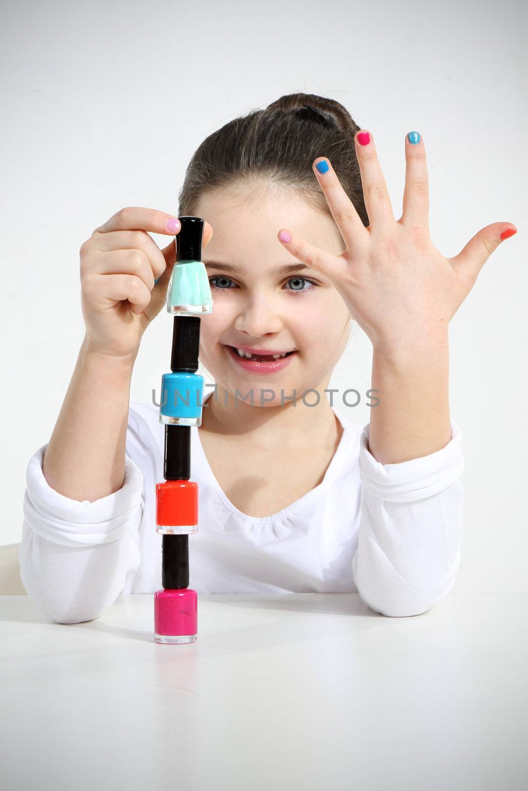 Little girl builds a pyramid using nail polishes by robert_przybysz