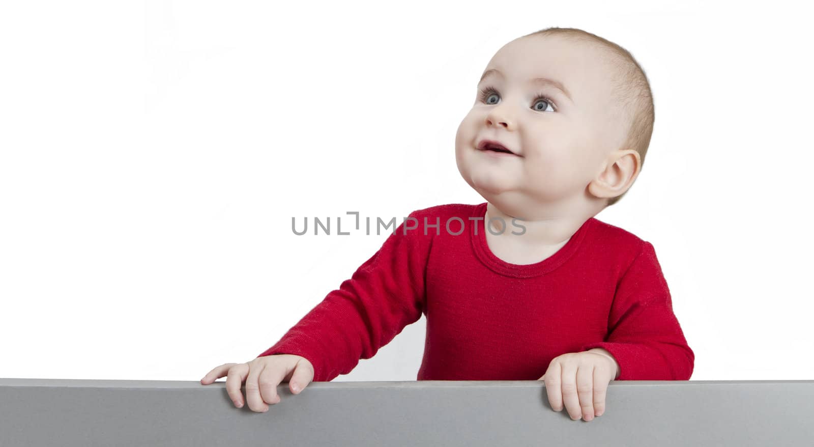 young baby standing at grey cardboard. isolate on white background