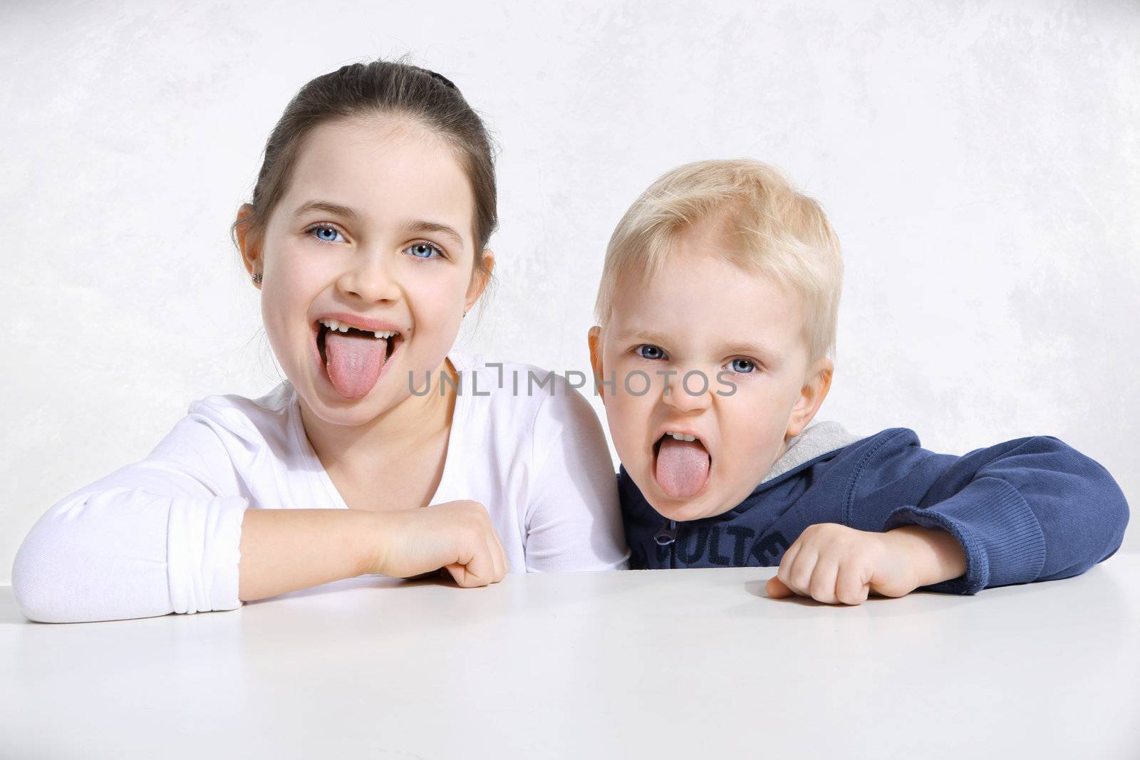 Brother and sister stick out tongues by robert_przybysz