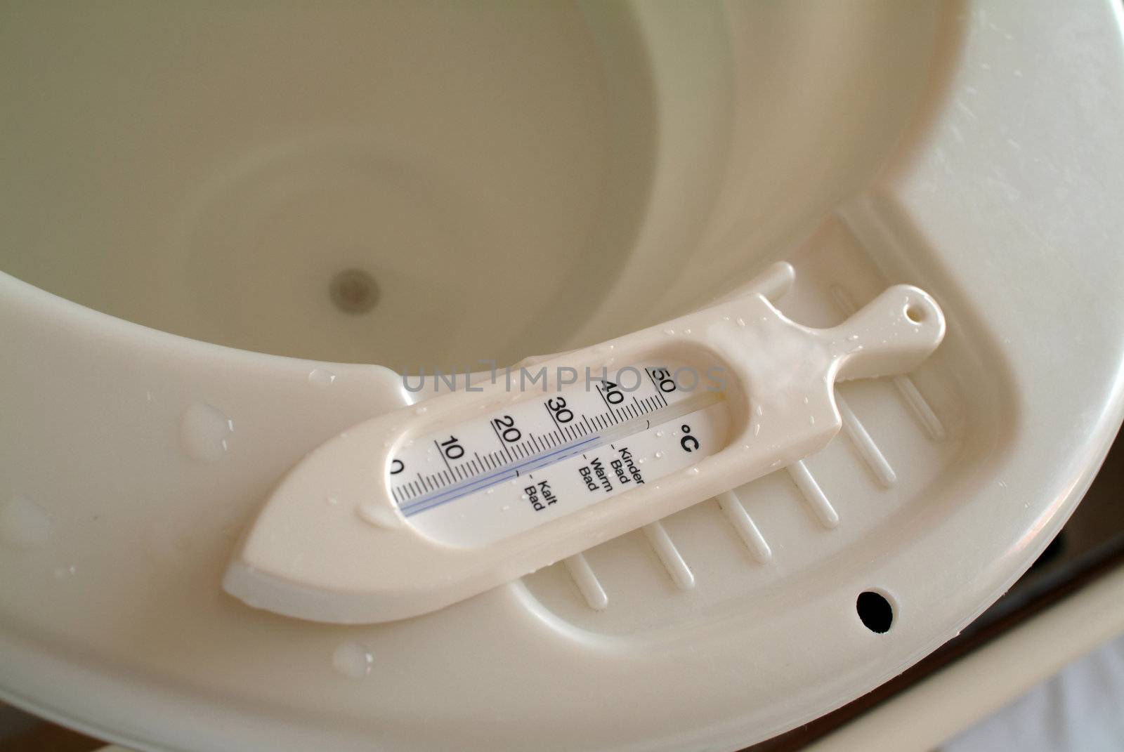 Thermometer on the rim of a baby bath tub