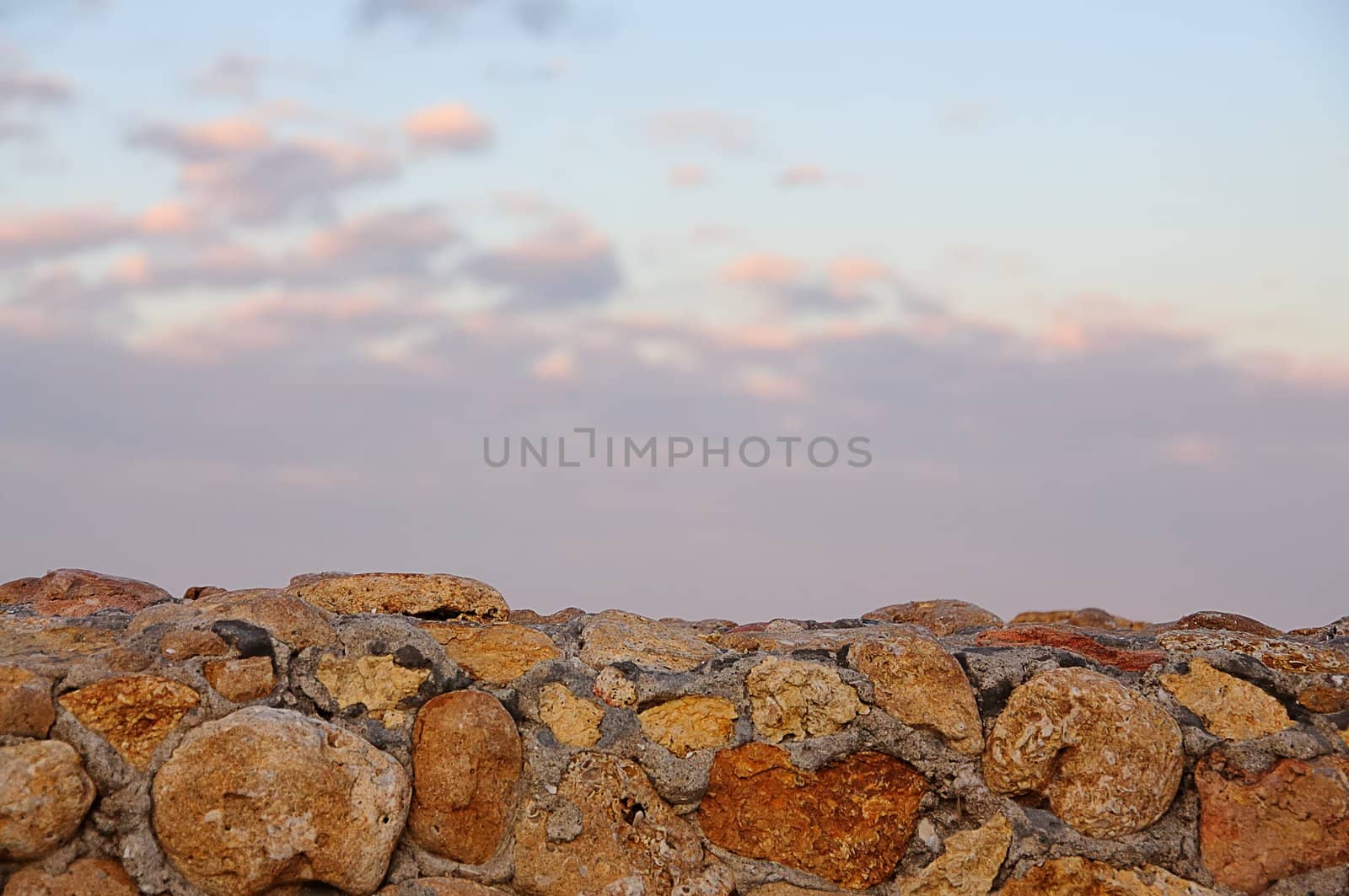 landscape, a stone wall and the sunset sky for background