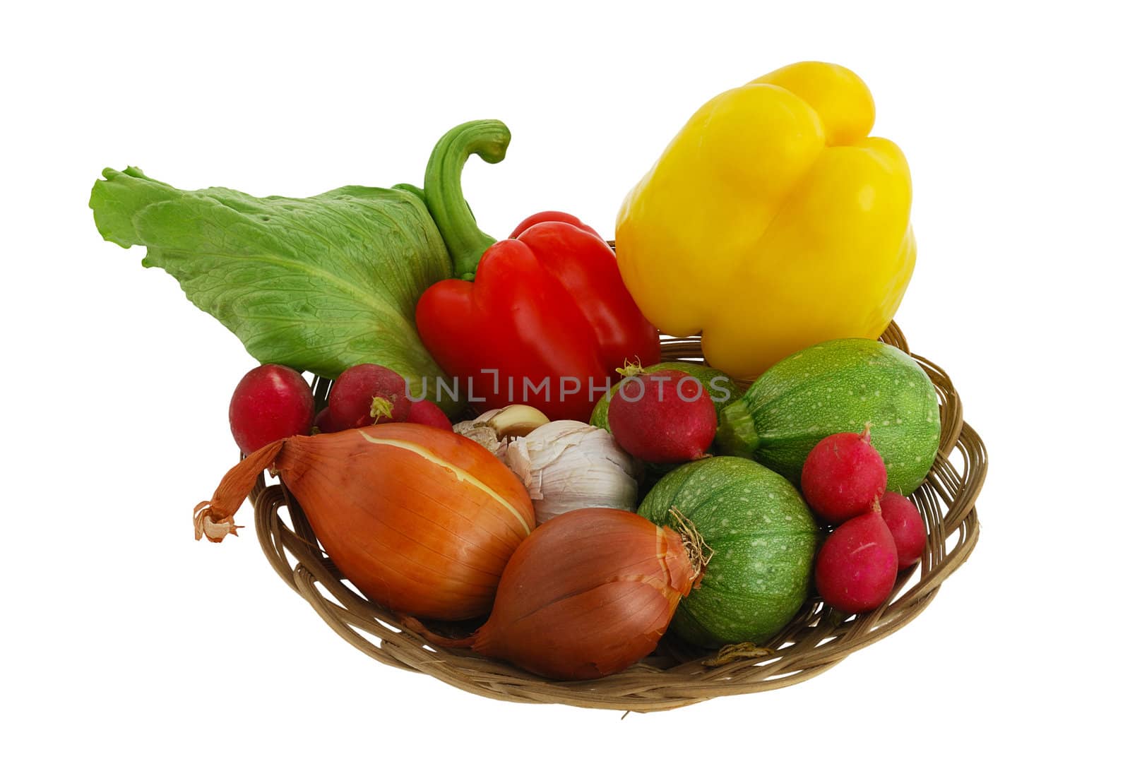Harvested vegetables mix including  radish, sweet peppers, garlic, onion, lettuce  and squash in straw bowl isolated on white background