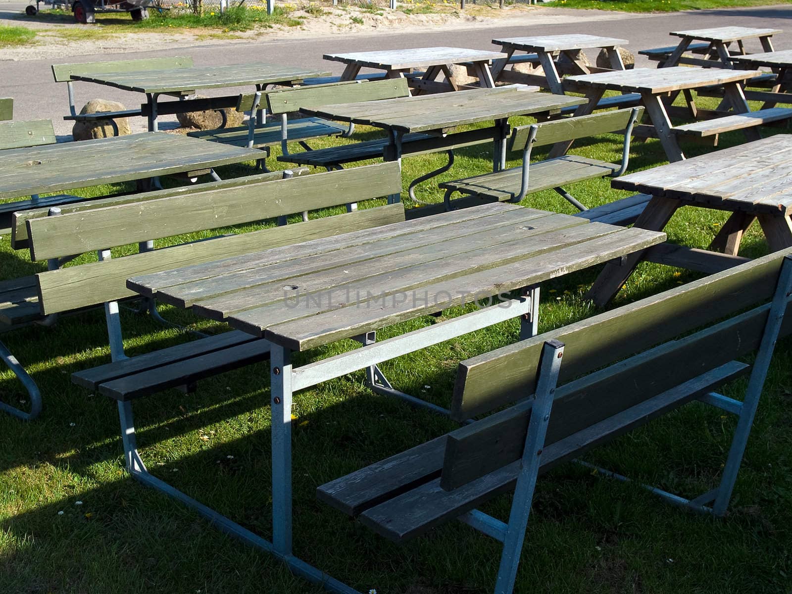 Wooden picnic tables arranged outdoors in nature