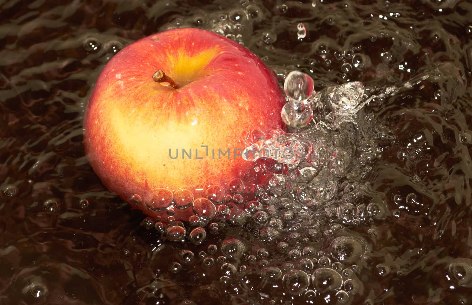 Ripe red apple is under the running water