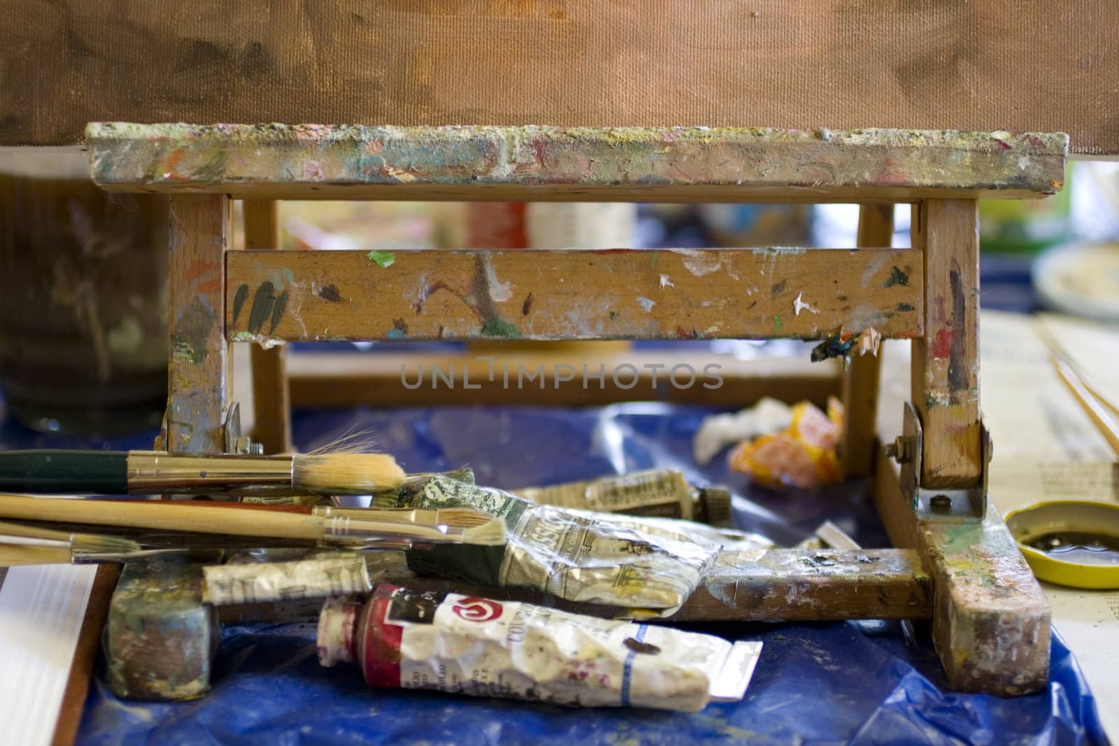 Atelier. Palette with colors, easel in the background