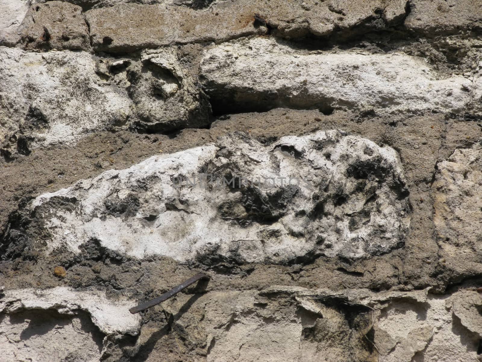 Piece of stone wall surface with metal pin