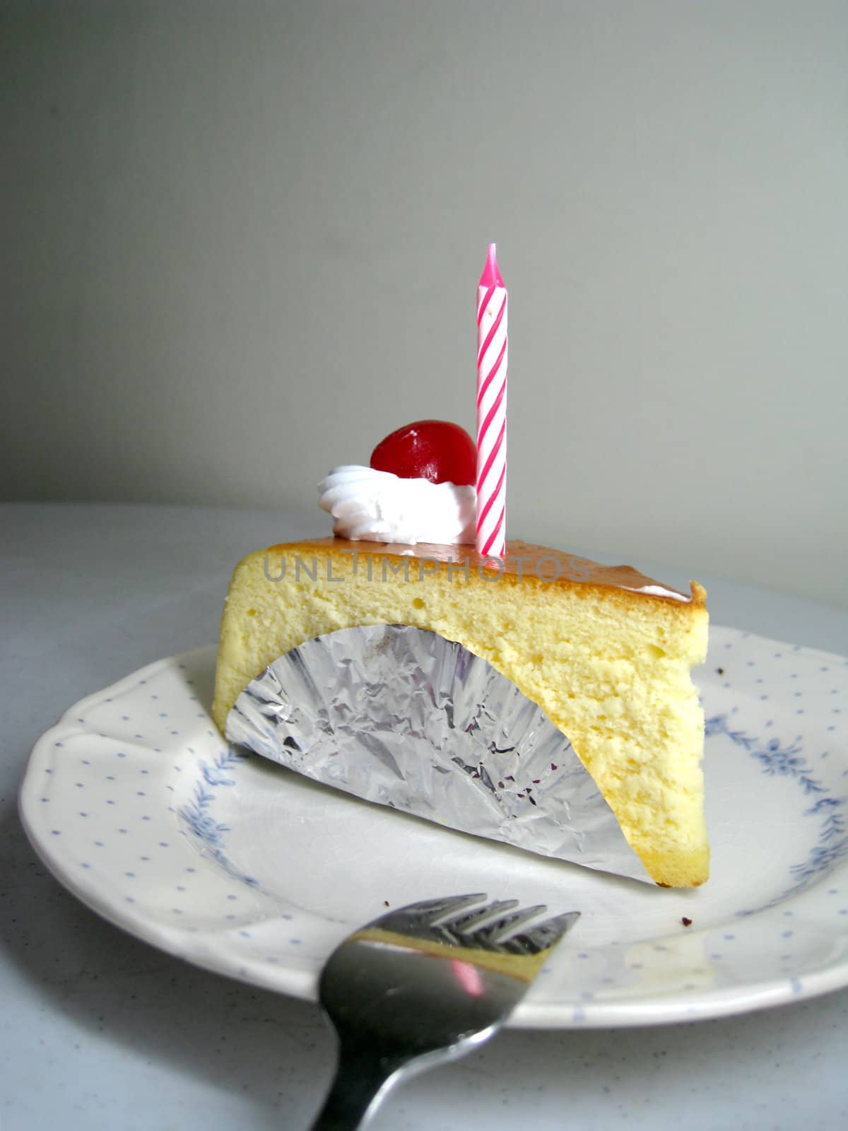 a slide of cheese cake with candle on top