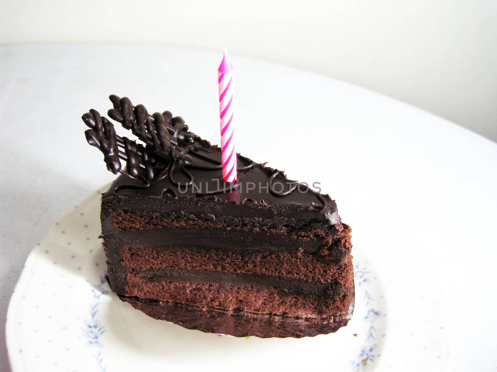 a slide of chocolate cake with candle on top